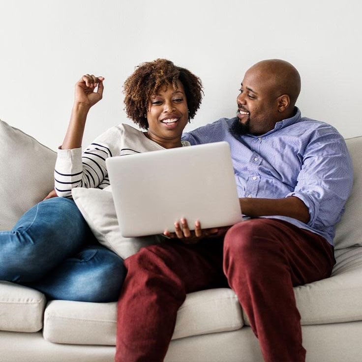 Two adults learning together on a laptop at home